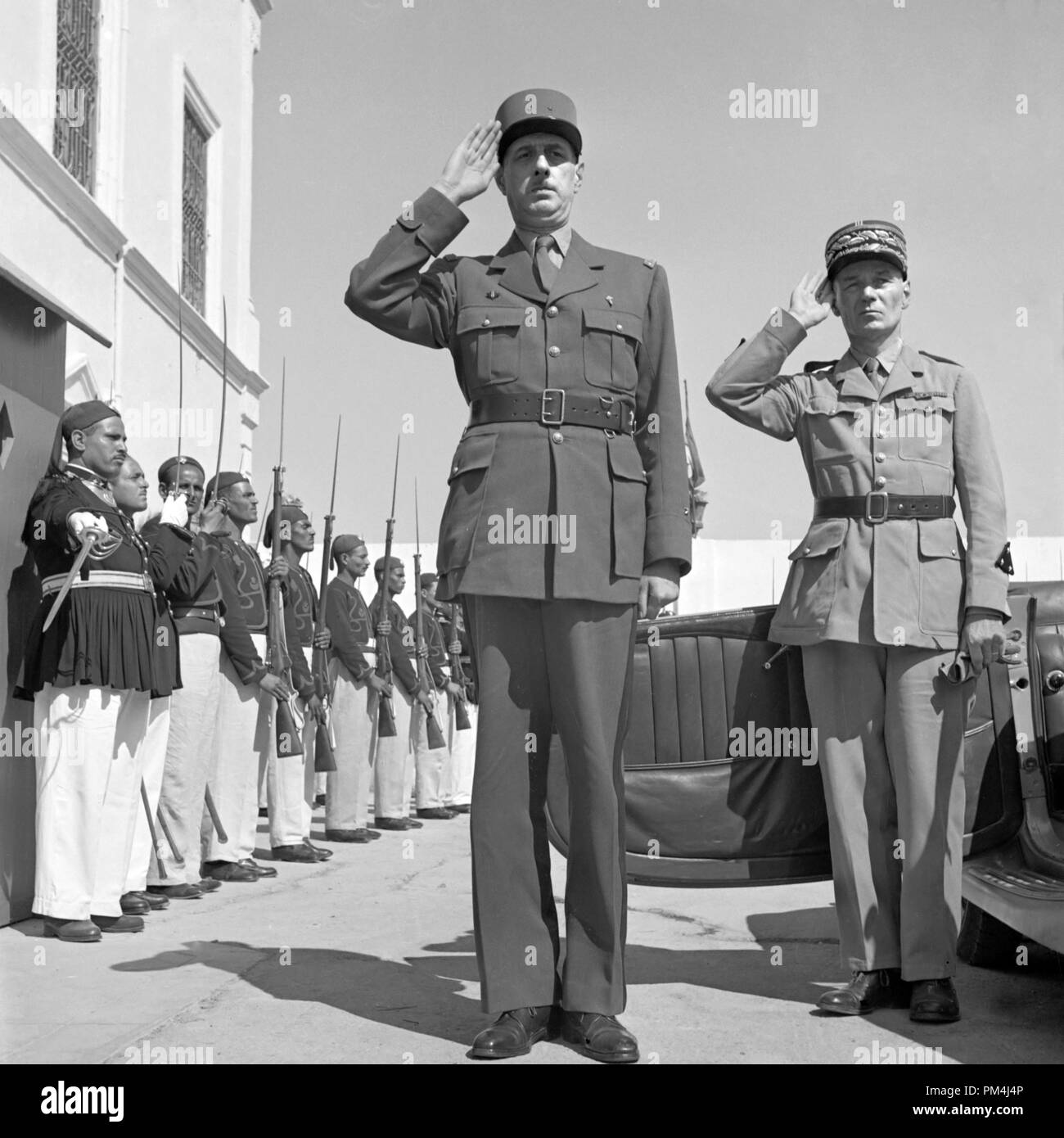 Le général de Gaulle, accompagné du Général Mast, saluant comme le groupe joue Marseillaise à l'extérieur du palais d'été de la baie de Tunis. Juin 1943 Référence #  1003 521THA Banque D'Images