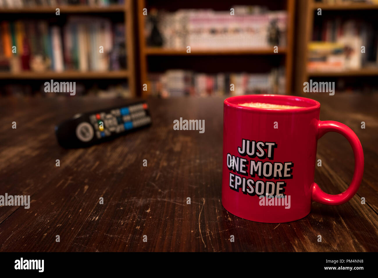 Tasse de café rouge avec l'inscription qu'un autre épisode et télécommande Banque D'Images