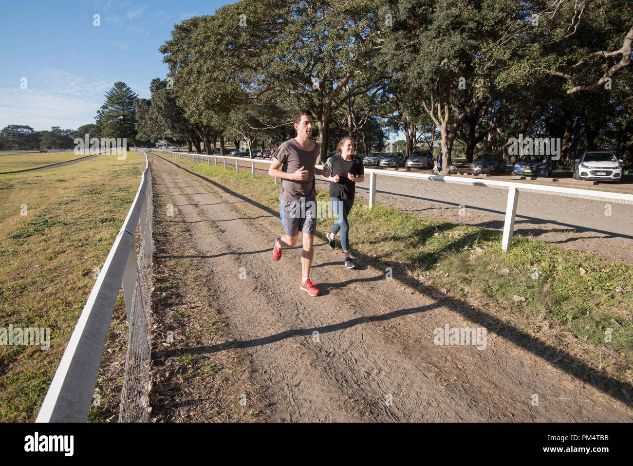 Deux personnes le jogging ou la course et de l'exercice à Sydney Australie's Centennial Park sur un matin de printemps Banque D'Images