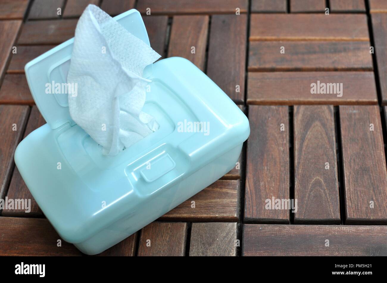 Concept de lingettes de nettoyage intérieur en plastique dans une boîte bleue sur fond de bois brun with copy space Banque D'Images