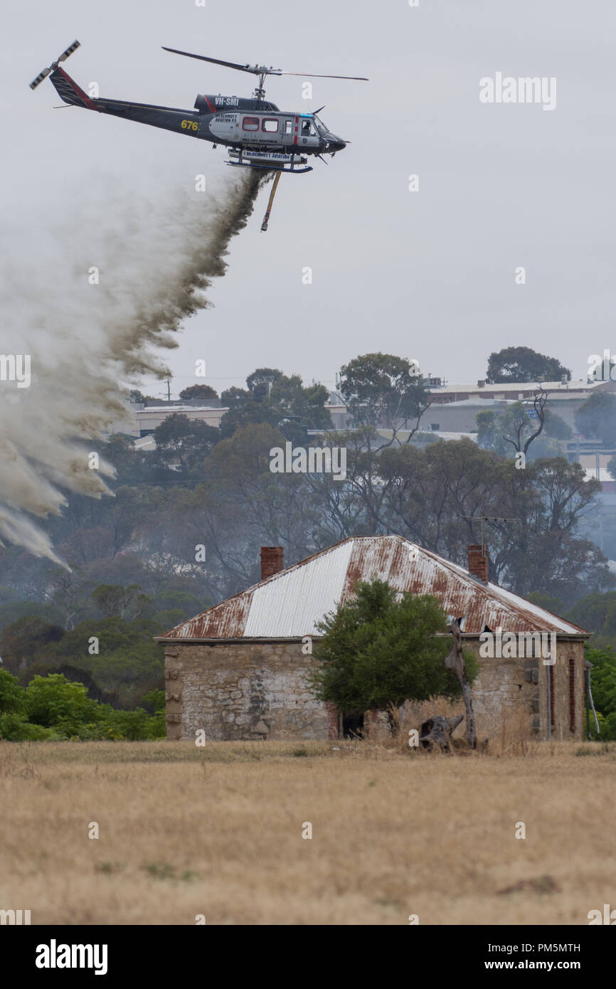 Hélicoptère de lutte contre l'abandon de l'eau sur un incendie au nord de Perth la menace d'une ferme historique Banque D'Images
