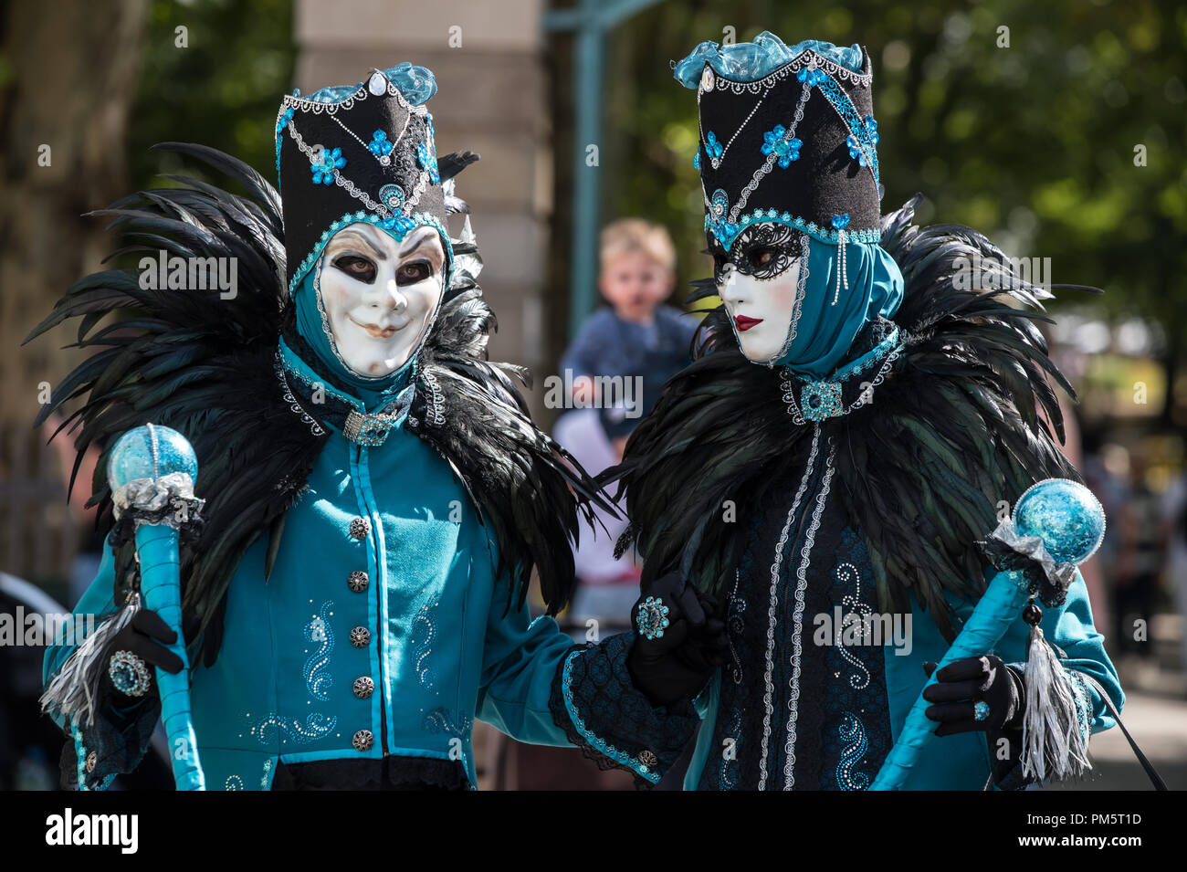 Un homme et une femme en noir et turquoise costumes vénitiens à pied la rue pendant le carnaval Banque D'Images