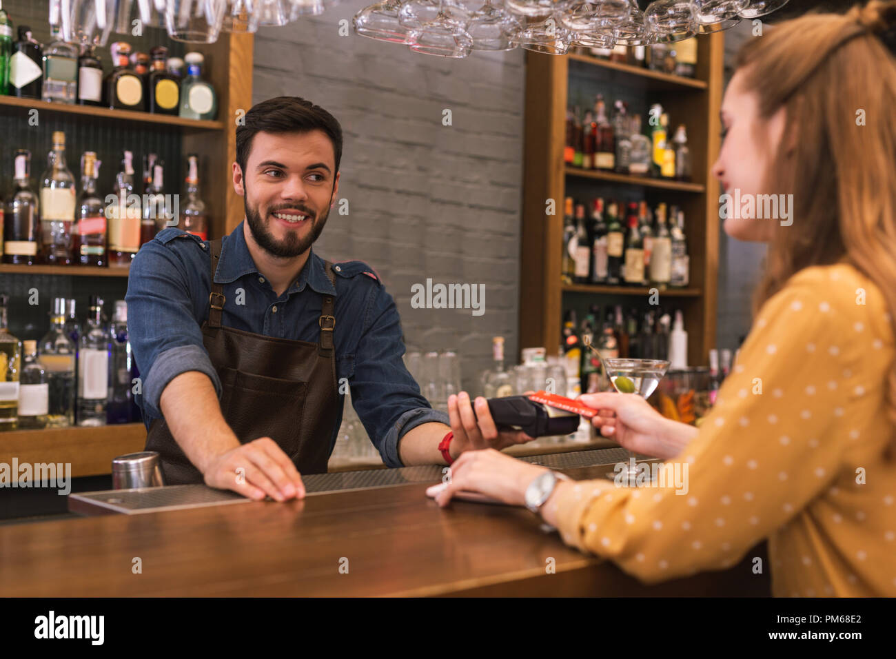 Barman gai smiling while son client paie la facture Banque D'Images