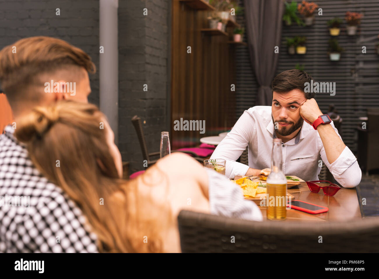 Jeune homme froncer et l'ennui avec ses amis romantique Banque D'Images