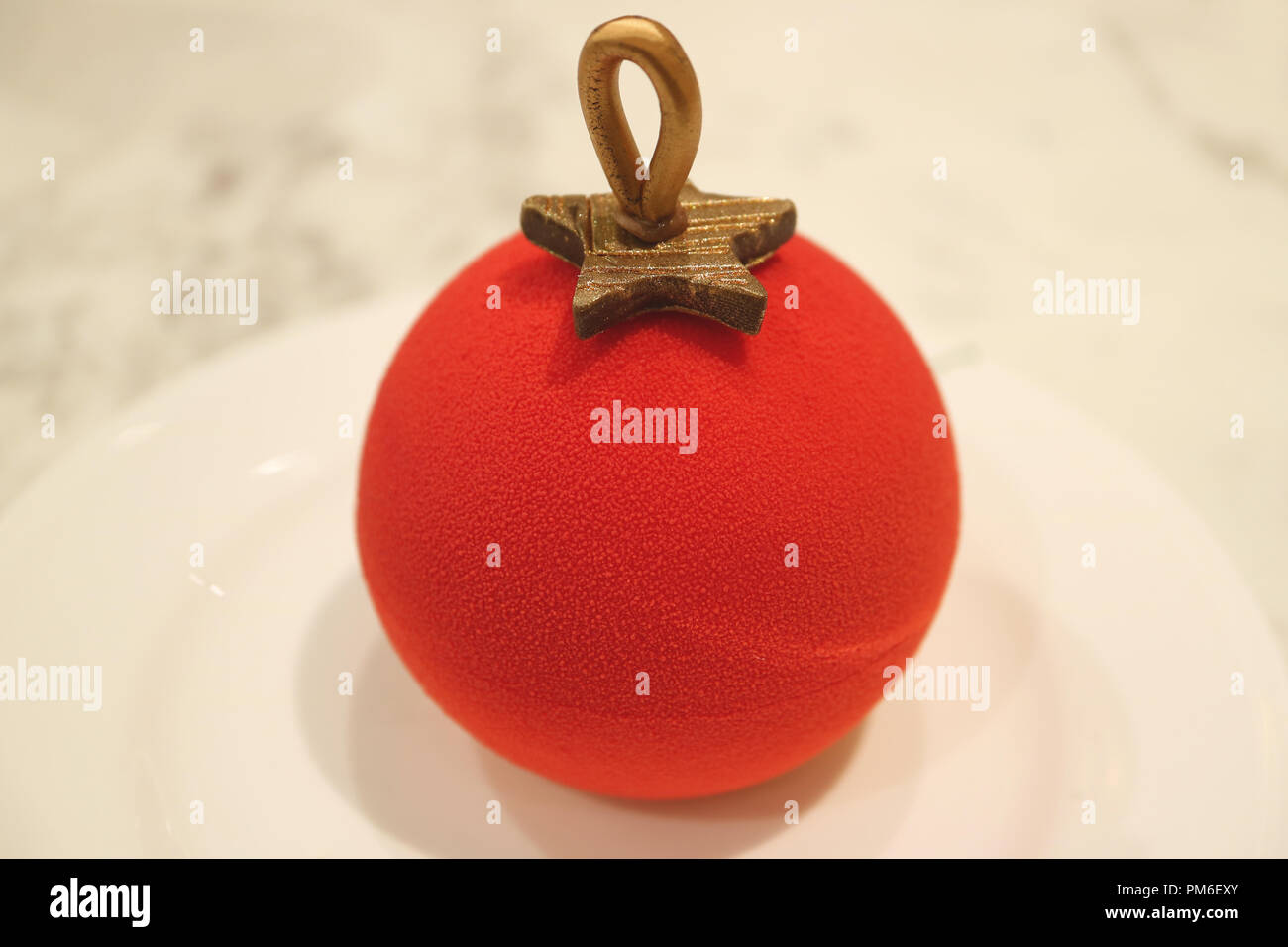 Velours rouge vibrante boule de noël ornement Shaped cake with intérieur servi sur plaque blanche Banque D'Images