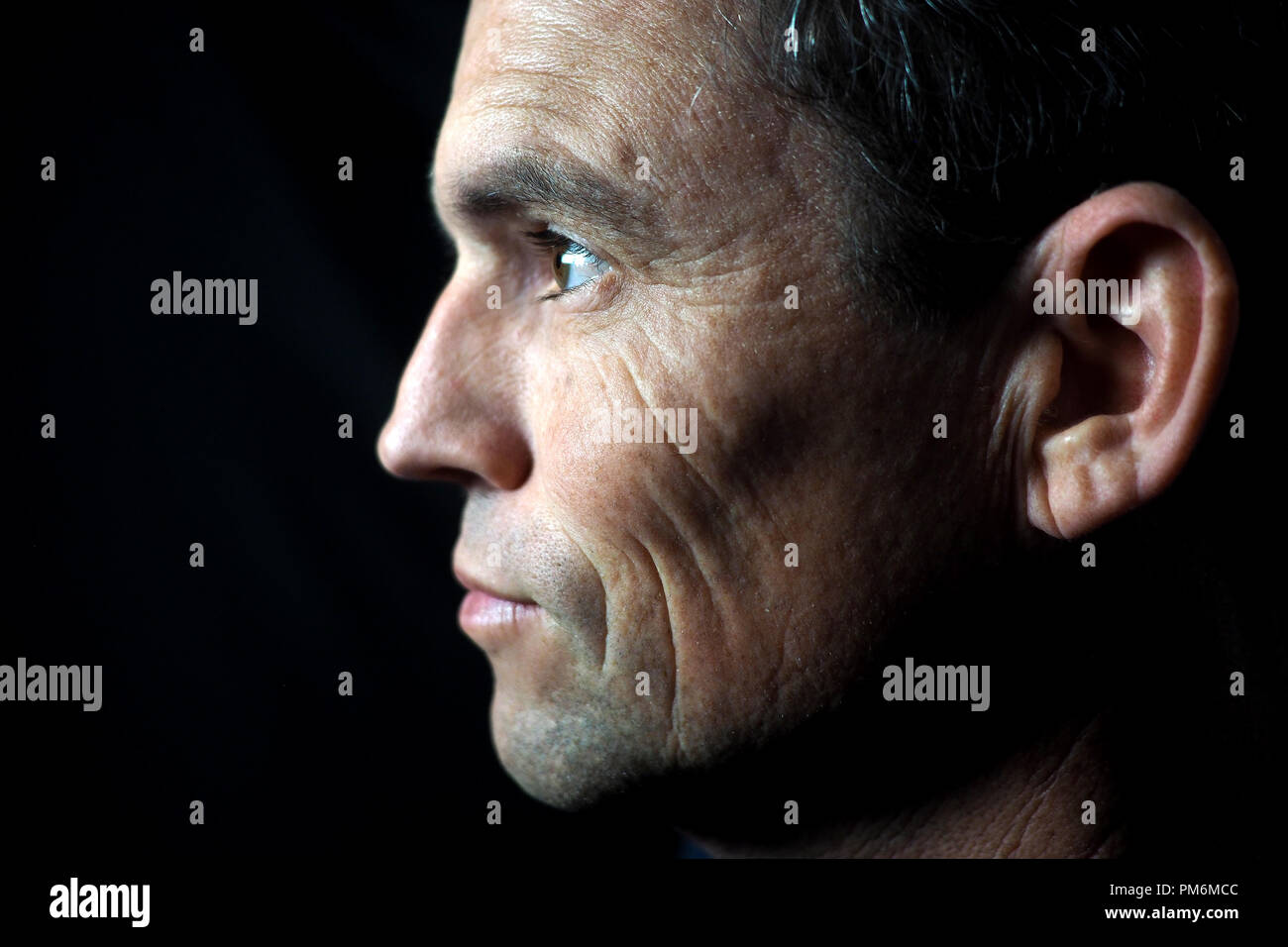 Portrait d'un homme sur fond noir, de profil Banque D'Images