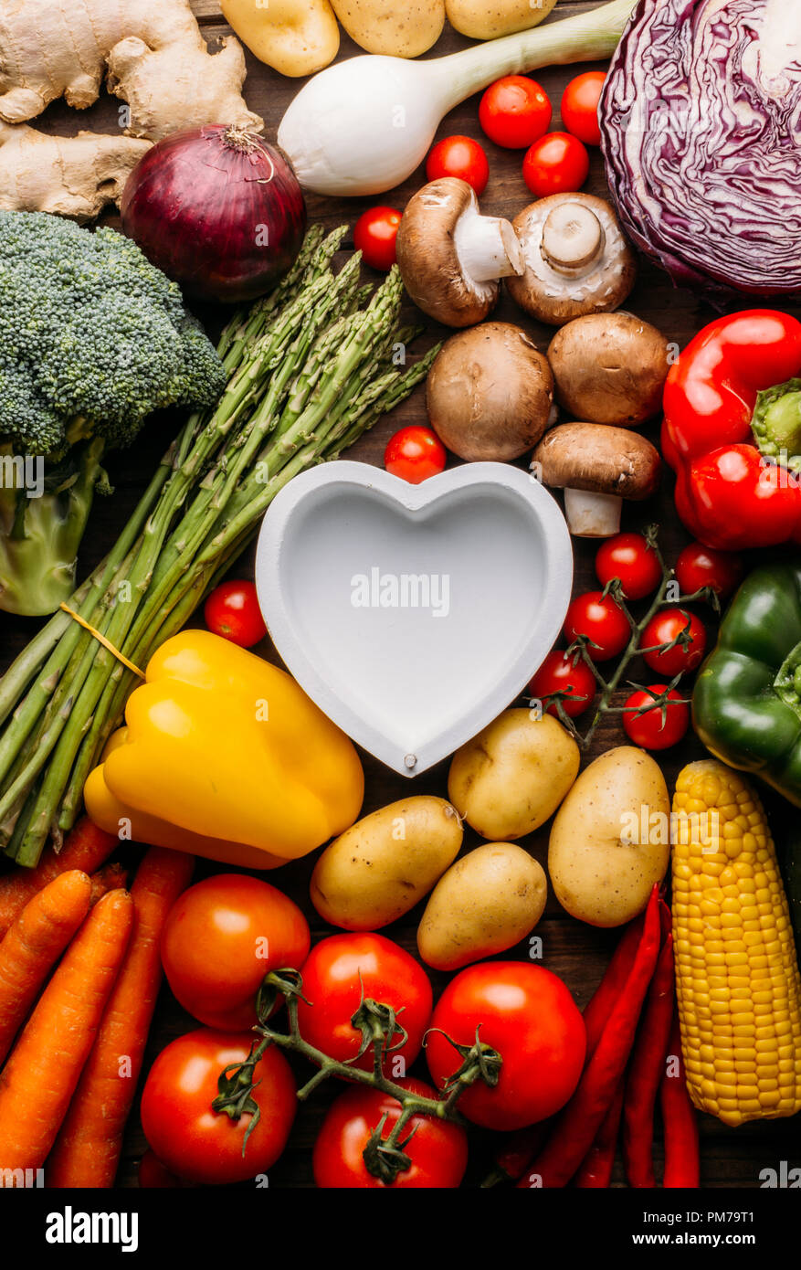 Vue de dessus d'une table en bois plein de légumes et dans le milieu de l'image d'un plat en forme de coeur vide conceptuel, photo, amant de l'alimentation Banque D'Images