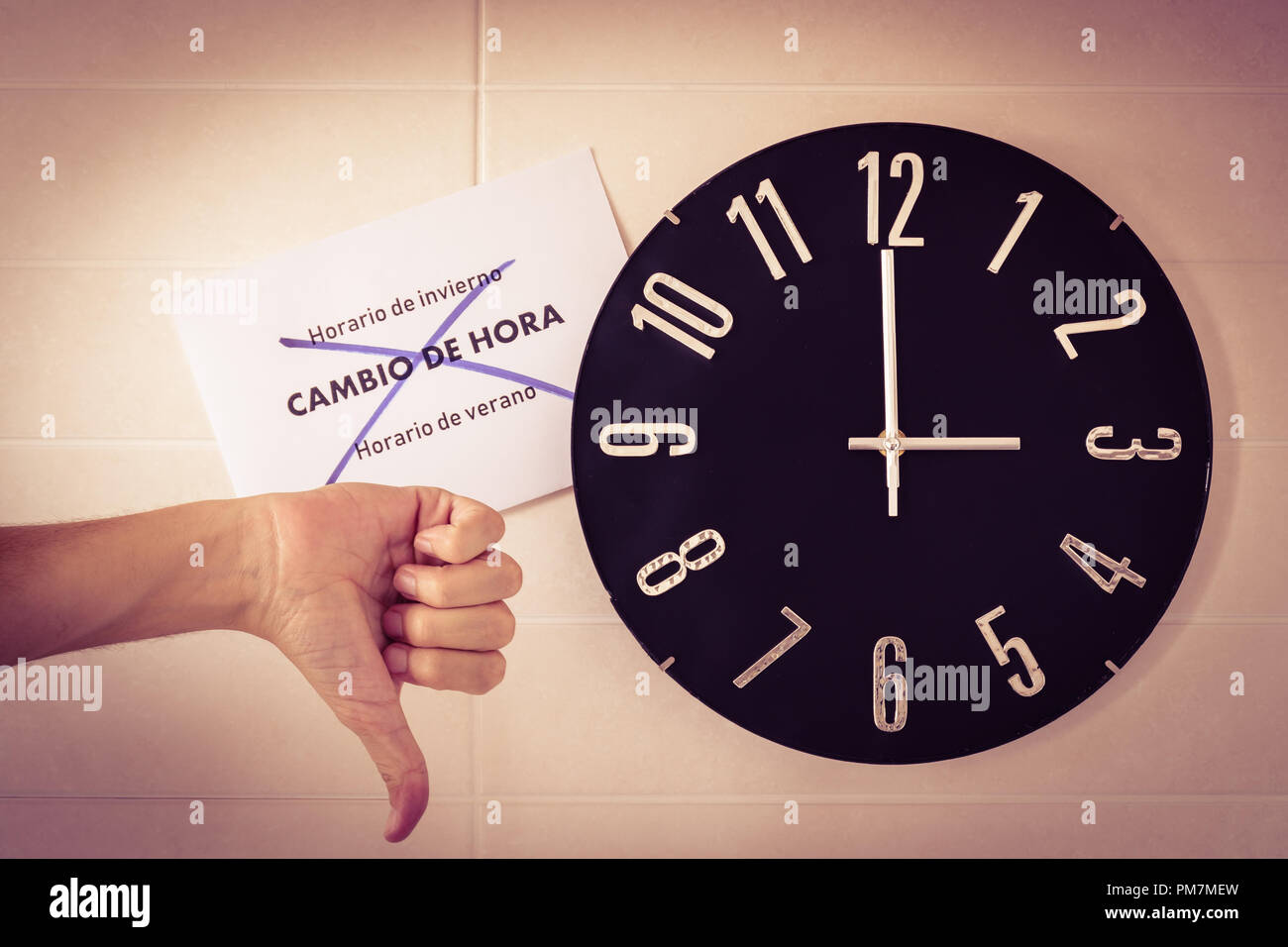 Big Black horloge de mur blanc. Changement d'heure. Le changement d'heure. Enquête auprès de l'Union européenne. Geste de désaccord . Le pouce de l'homme de race blanche. Bannière espagnole. Banque D'Images