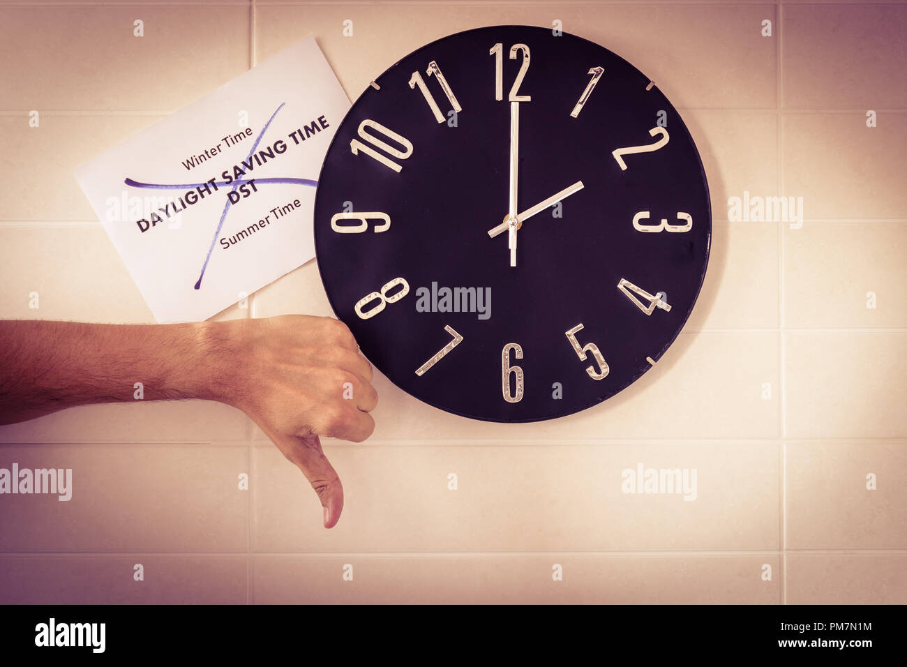 Big Black horloge de mur blanc. Changement d'heure. Le changement d'heure. Enquête auprès de l'Union européenne. Geste de désaccord . Le pouce de l'homme de race blanche. English Page d'ouverture. Banque D'Images