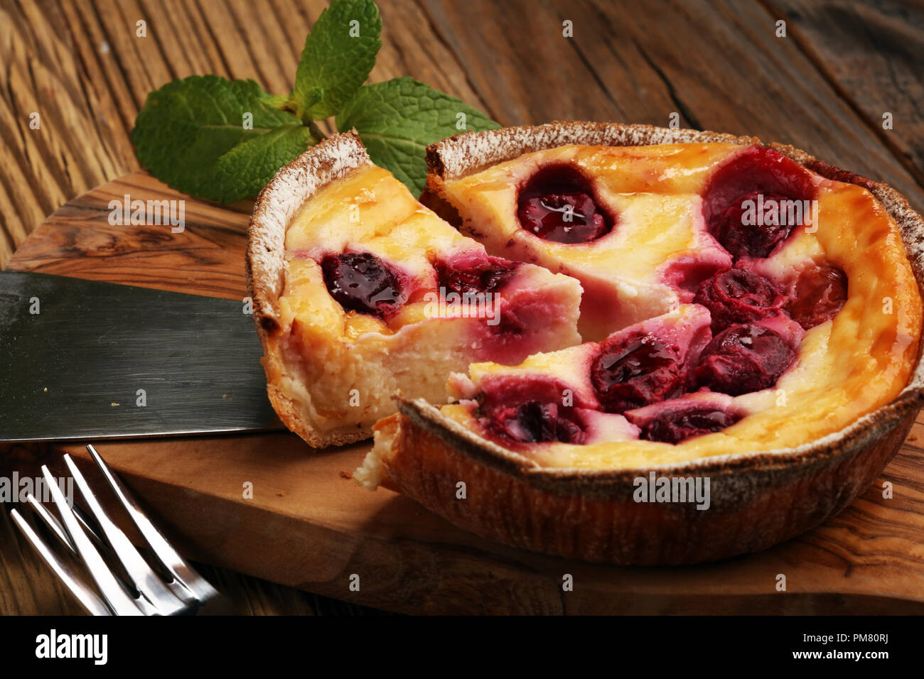 Cherry cheesecake Dessert - Gâteau au fromage avec fruits rouges et sauce à la menthe verte Banque D'Images