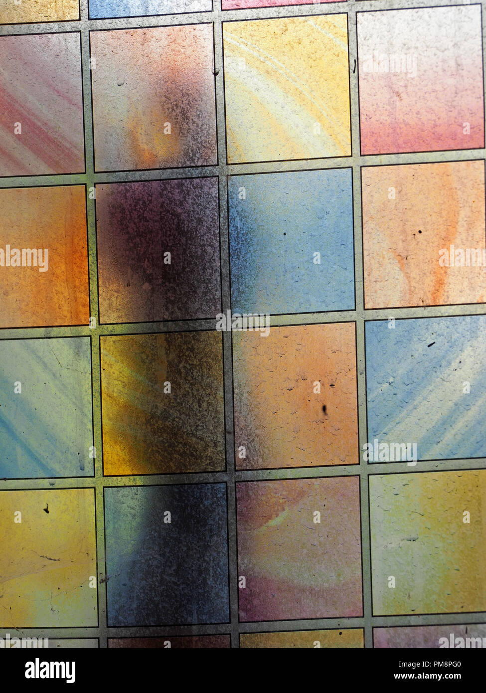 Ombre sur vitrail crasseux avec panneaux contrastés pastel rectangulaire, Ariège Pyrénées, France Banque D'Images