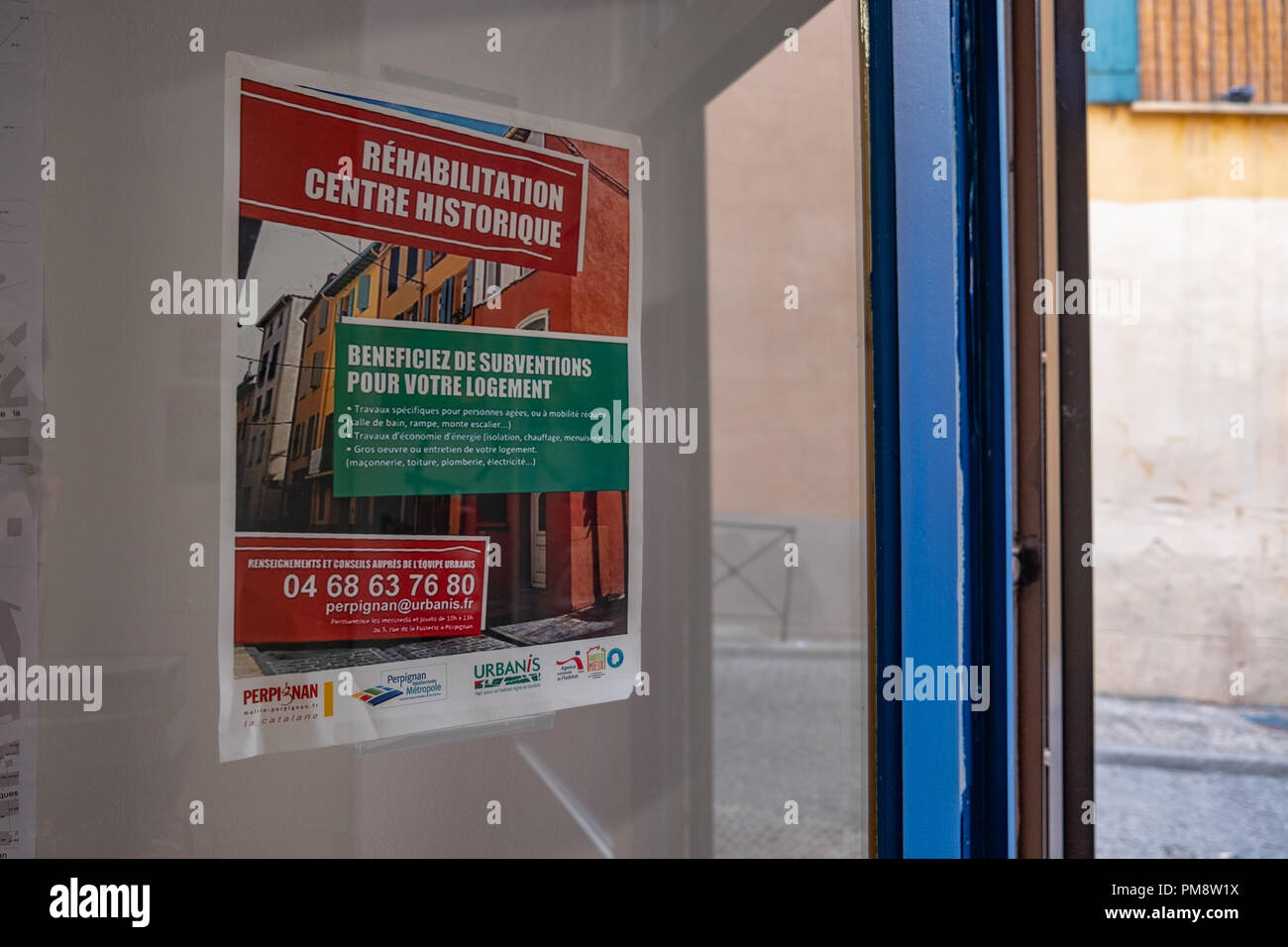 L'affiche qui communique aux voisins le projet de réhabilitation du centre  historique est vu sur la porte de l'office municipal de l'urbanisme. La  mairie de Perpignan, France, a relancé une nouvelle rénovation