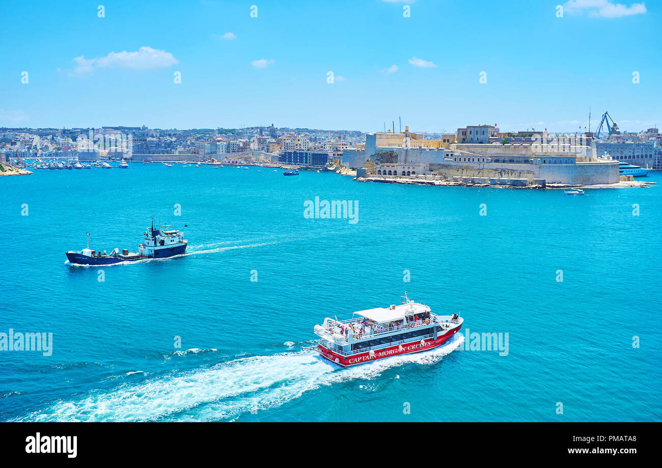 La Valette, MALTE - 17 juin 2018 : Le bateau de plaisance de touristes fait un voyage le long de la Valette Grand Port avec une vue sur Saint Angelo Fort sur le ta Banque D'Images