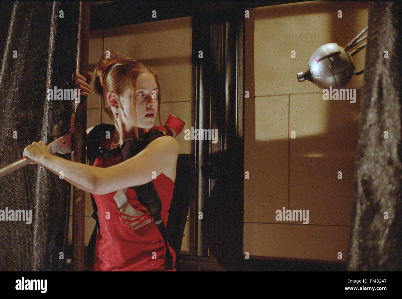 Kristen Stewart utilise un outil de bas-technologie pour désactiver un périphérique de sécurité high-tech. "Catch que Kid' (2003) Banque D'Images