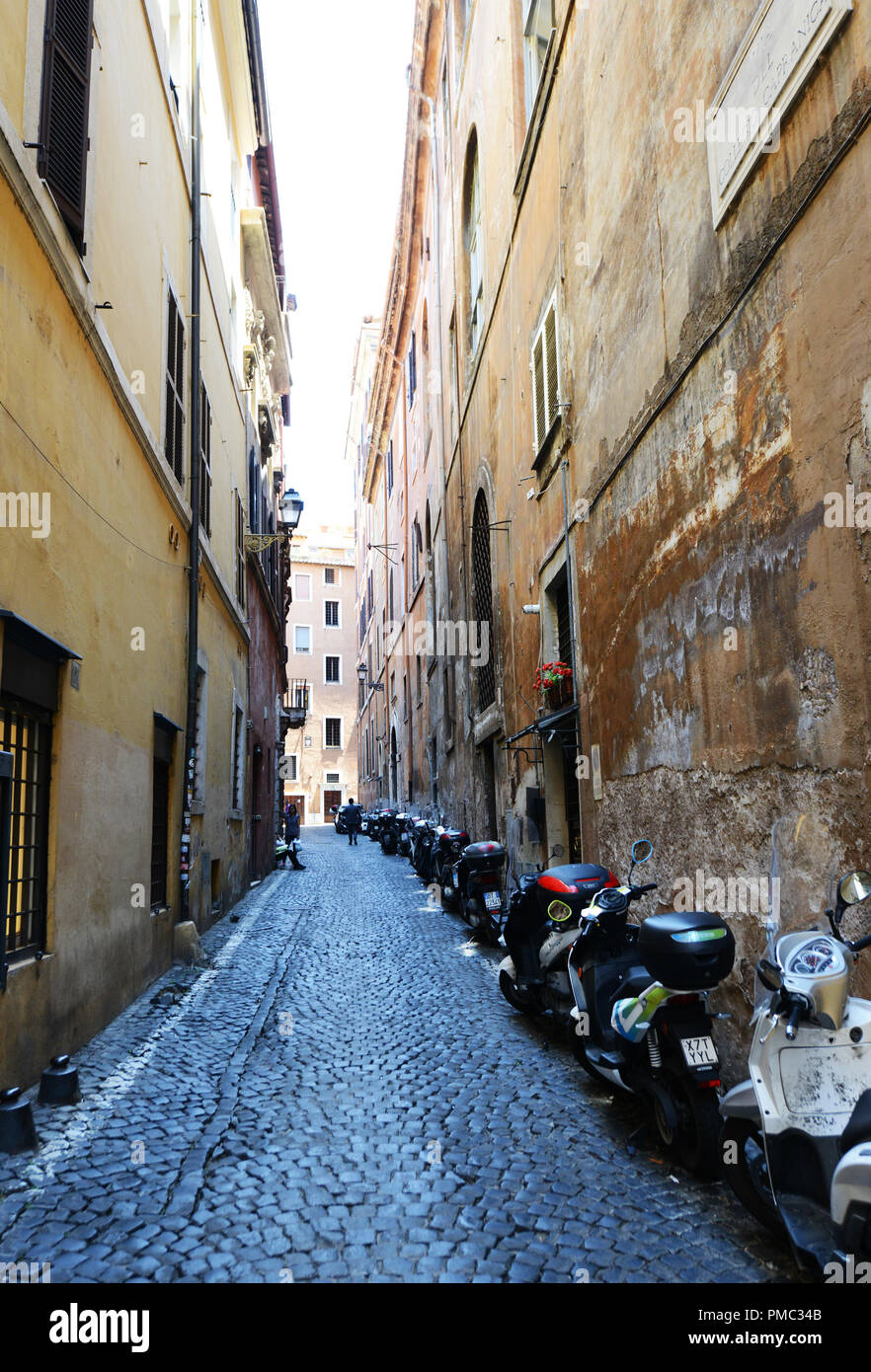 Une rangée de scooters en stationnement sur une étroite rue pavée, à Rome. Banque D'Images