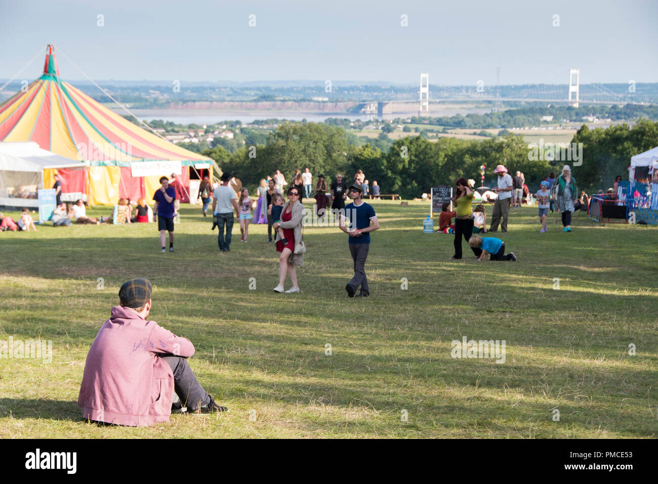 Chepstow, Pays de Galles - 16 Août : un jeune couple est assis près du chapiteau et la hausse Avalon jouit de la vue sur la Severn Bridge le 16 août 2015 au Green Ga Banque D'Images