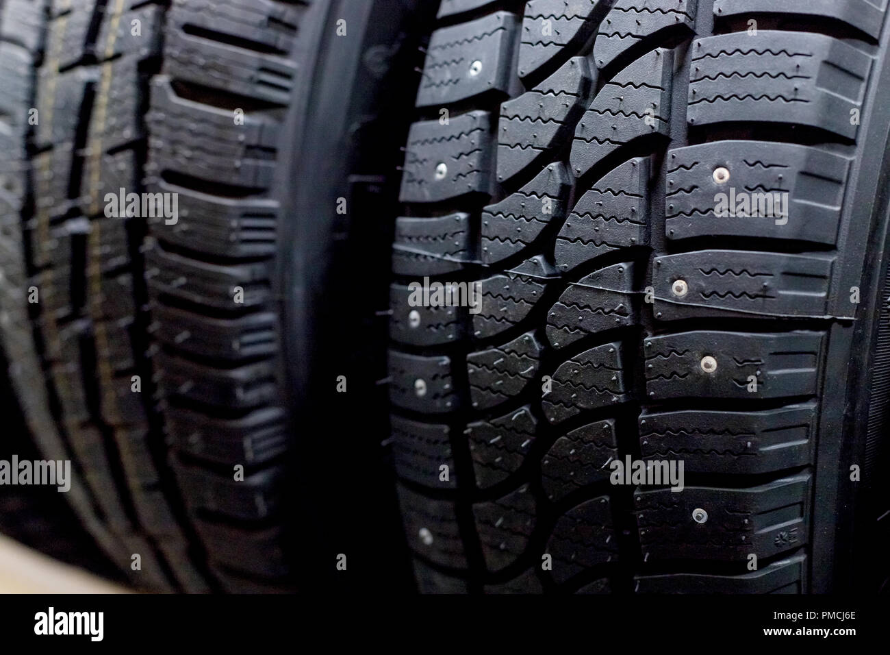 Les pneus de voiture en ligne isolé sur fond noir. des pneus pour roues pneus d'hiver et d'été. Boutique de pièces de rechange pour l'automobile, la vente de pneus et roues pour disques Banque D'Images