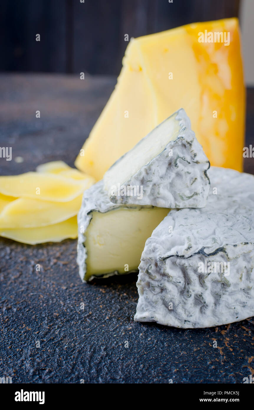 Différents types de fromages sur le plateau, assiette de fromage à partir d'un morceau de fromage à pâte dure, de fines tranches de fromage bleu, tête ronde Banque D'Images