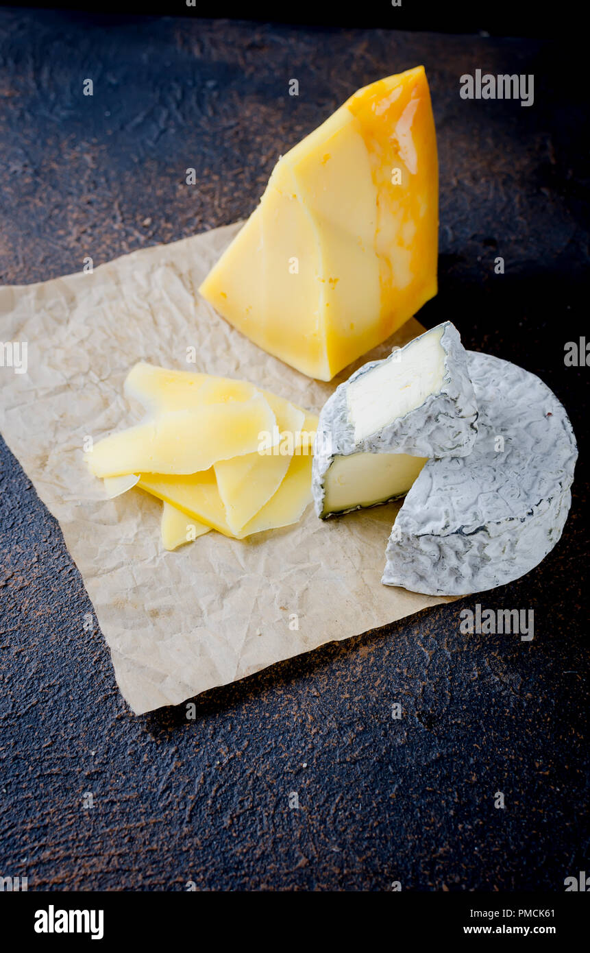 Différents types de fromages sur le plateau, assiette de fromage à partir d'un morceau de fromage à pâte dure, de fines tranches de fromage bleu, tête ronde Banque D'Images