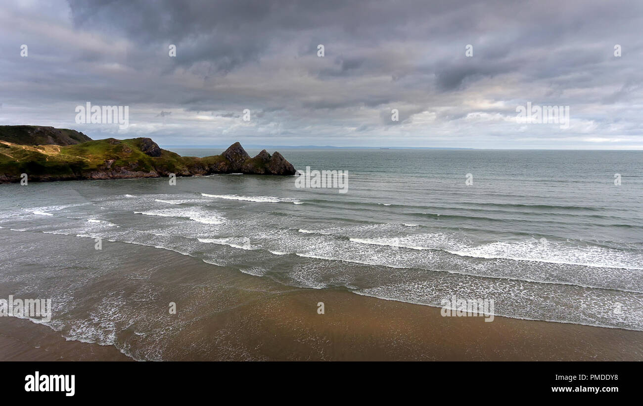 Surf blanc et nuages à trois Cliffs Bay South Wales Banque D'Images