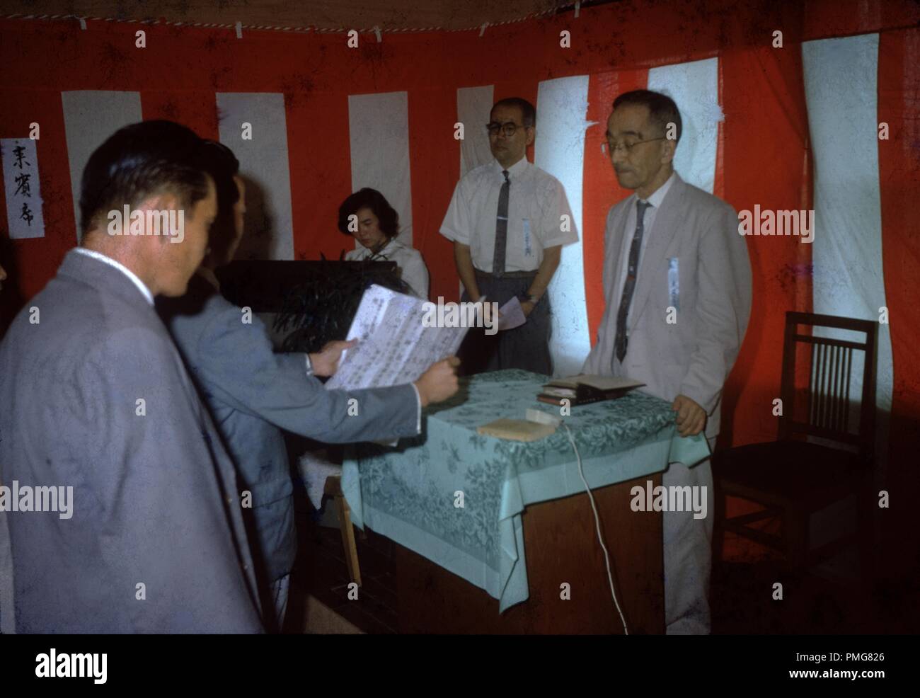 Résident local des services religieux, la lecture d'un script à un prêtre à l'église de la sainteté du centre de Tokyo, Tokyo, Japon, 1965. () Banque D'Images