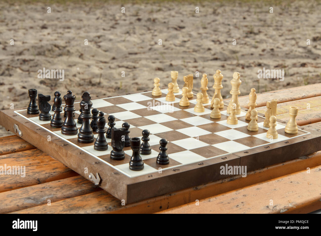 Conseil d'échecs avec pièces d'échecs sur le banc en bois. Jeu d'extérieur en bois avec pièces d'échecs Banque D'Images