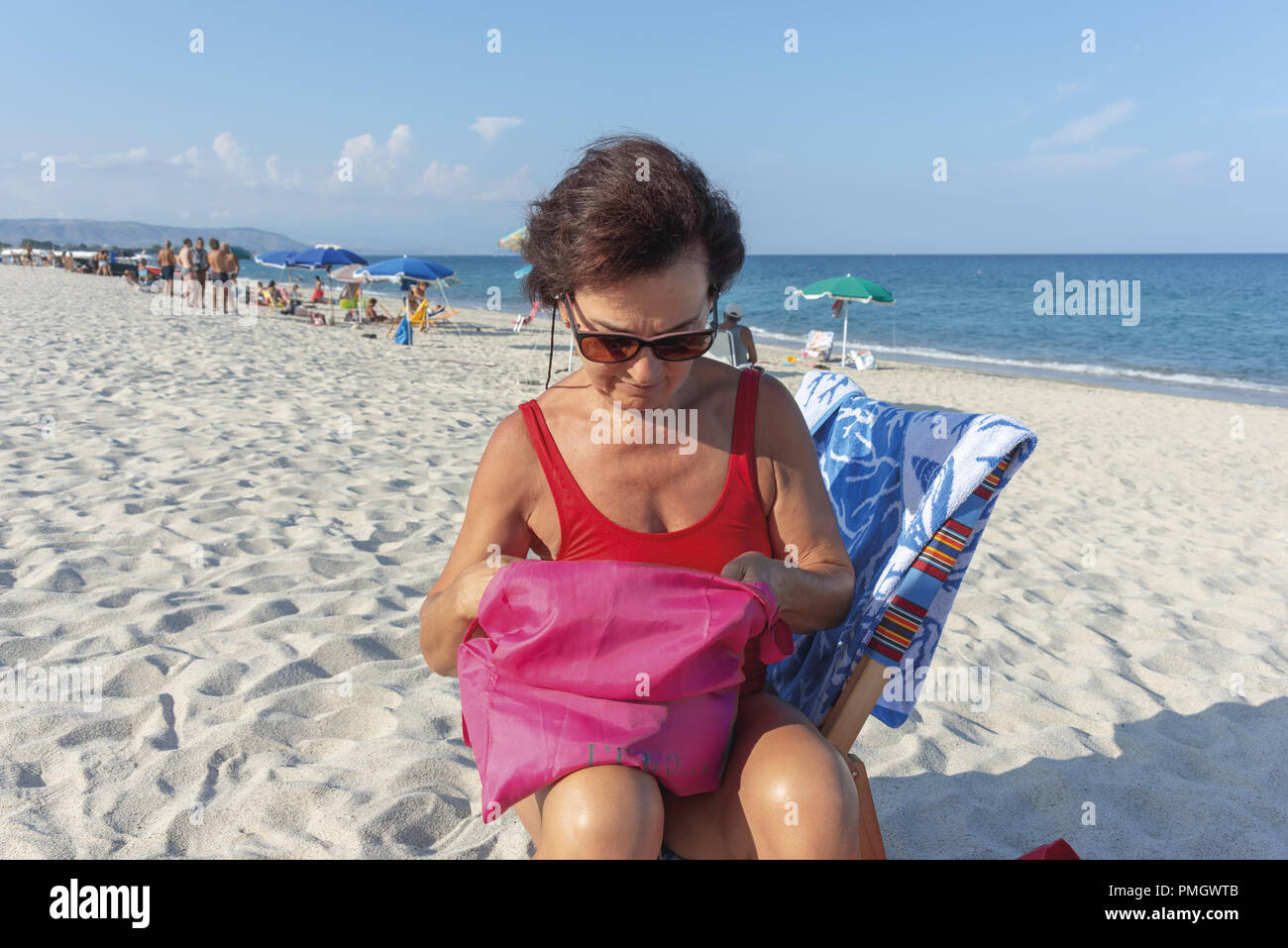 Italie Calabre femme d'âge moyen à la mer assis sur un lit de bronzage 8 Banque D'Images