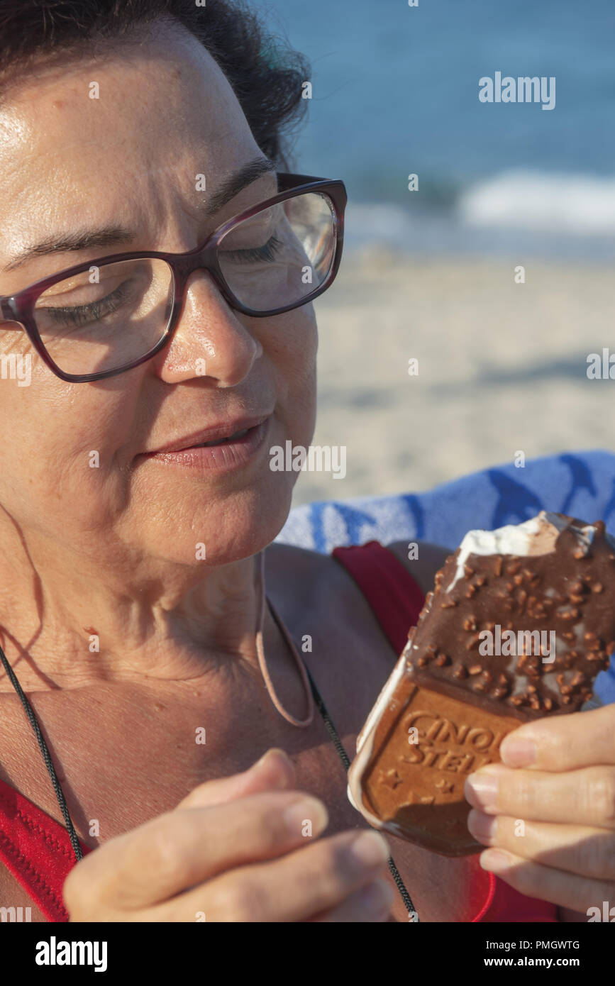 Italie Calabre femme d'âge moyen à la mer tandis que la consommation de crème glacée close-up 3 Banque D'Images