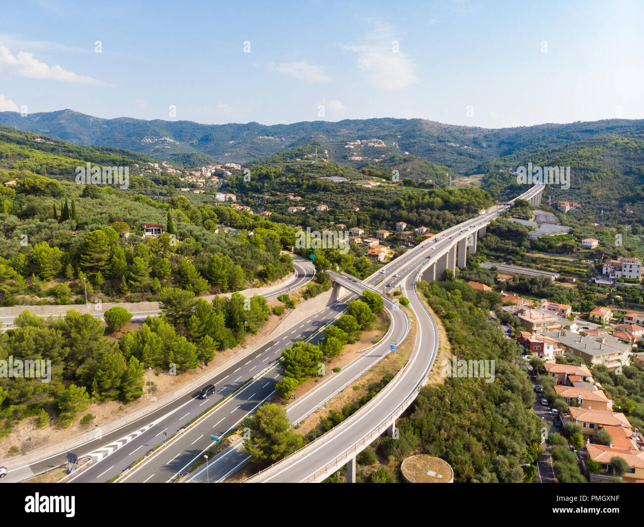 Vue aérienne de plusieurs voies traversant les villages et les collines de la forêt (Autostrada dei Fiori - A10) Ligurie Italie Banque D'Images