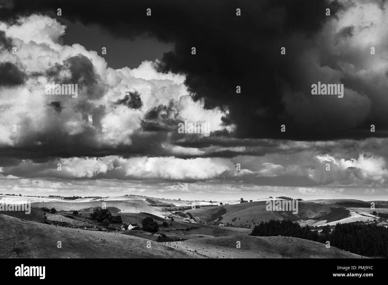 Des pluies dramatique nuages sur un paysage pittoresque dans le Shropshire Hills, Royaume-Uni. Le noir et blanc modifier Banque D'Images