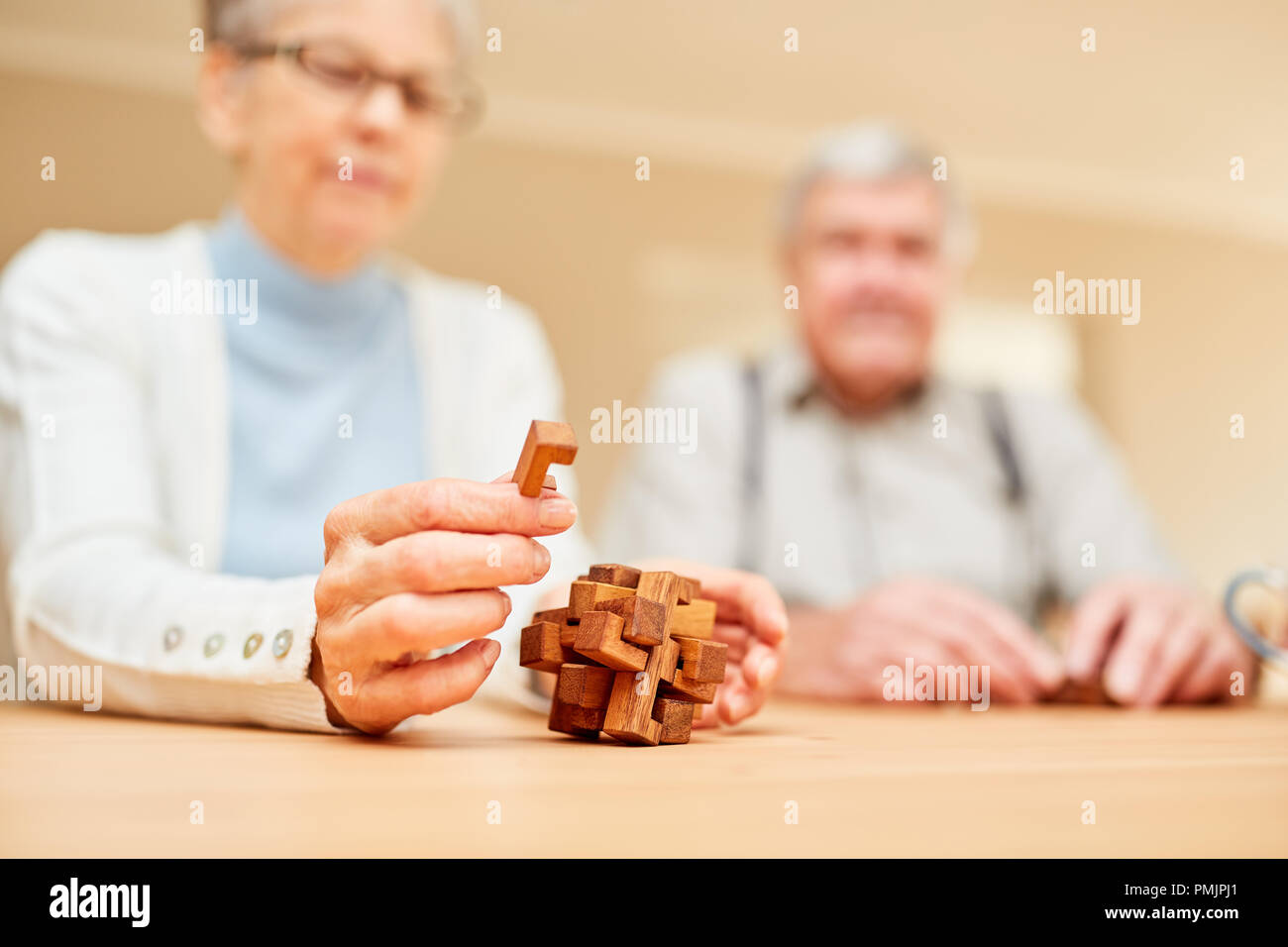 Les aînés atteints de démence jouer avec un puzzle en bois et de pratiquer la patience et la concentration Banque D'Images