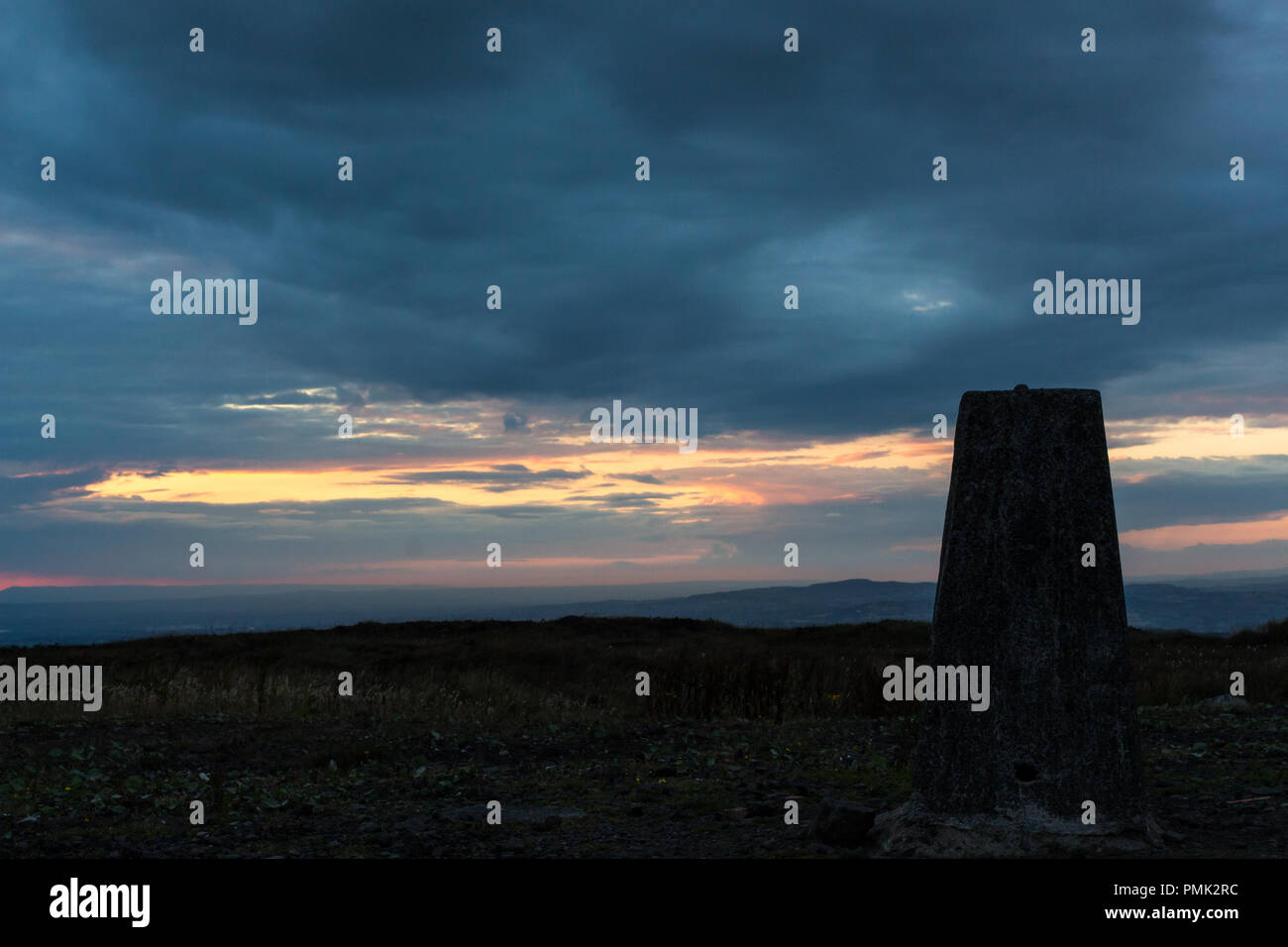 Trig point sur le sommet de la montagne de transmissions divisionnaires au coucher du soleil. Soirée d'été à Belfast, N.Ireland. Banque D'Images