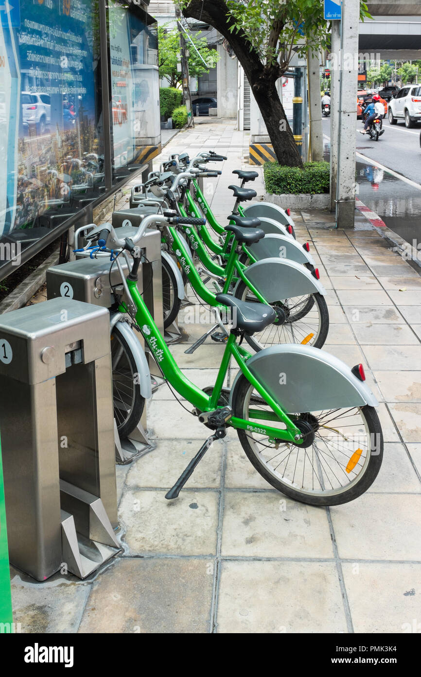 Rangée d'un service de location de vélos publics verts dans les stations d'accueil sur la rue à Bangkok, Thaïlande Banque D'Images