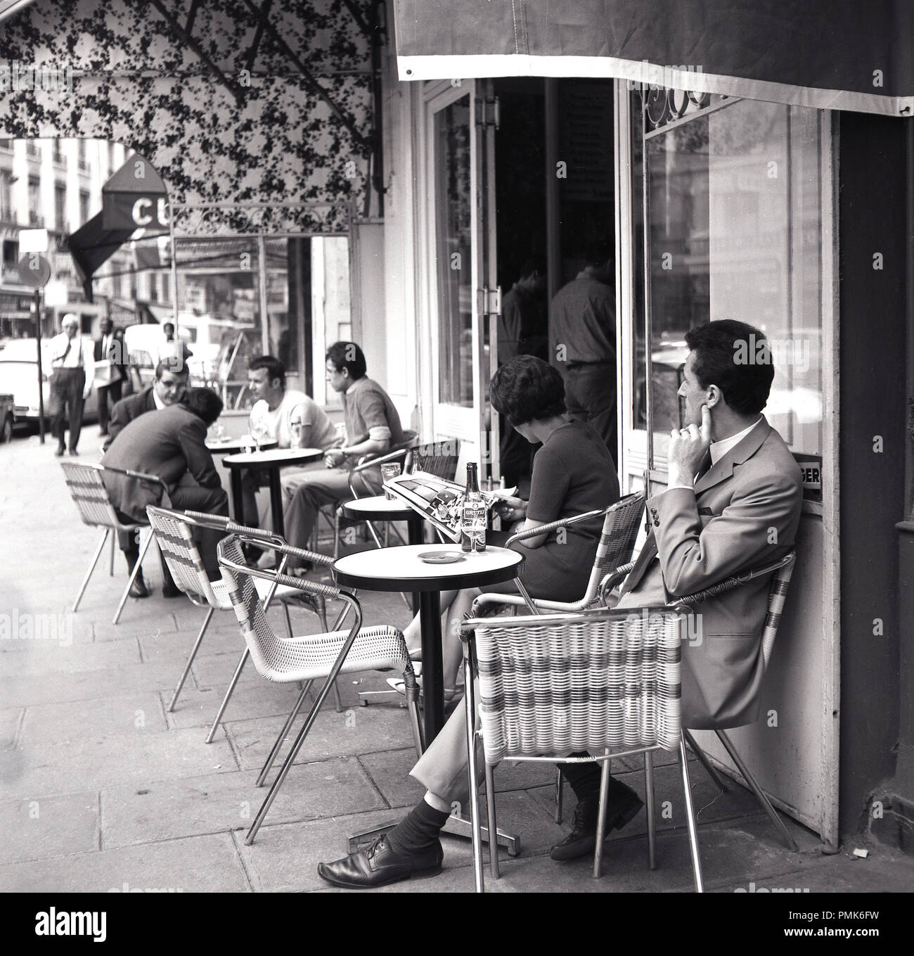 Années 1950, les Parisiens s'asseoir à des tables à l'extérieur d'un café sur le trottoir, Paris, France. Banque D'Images