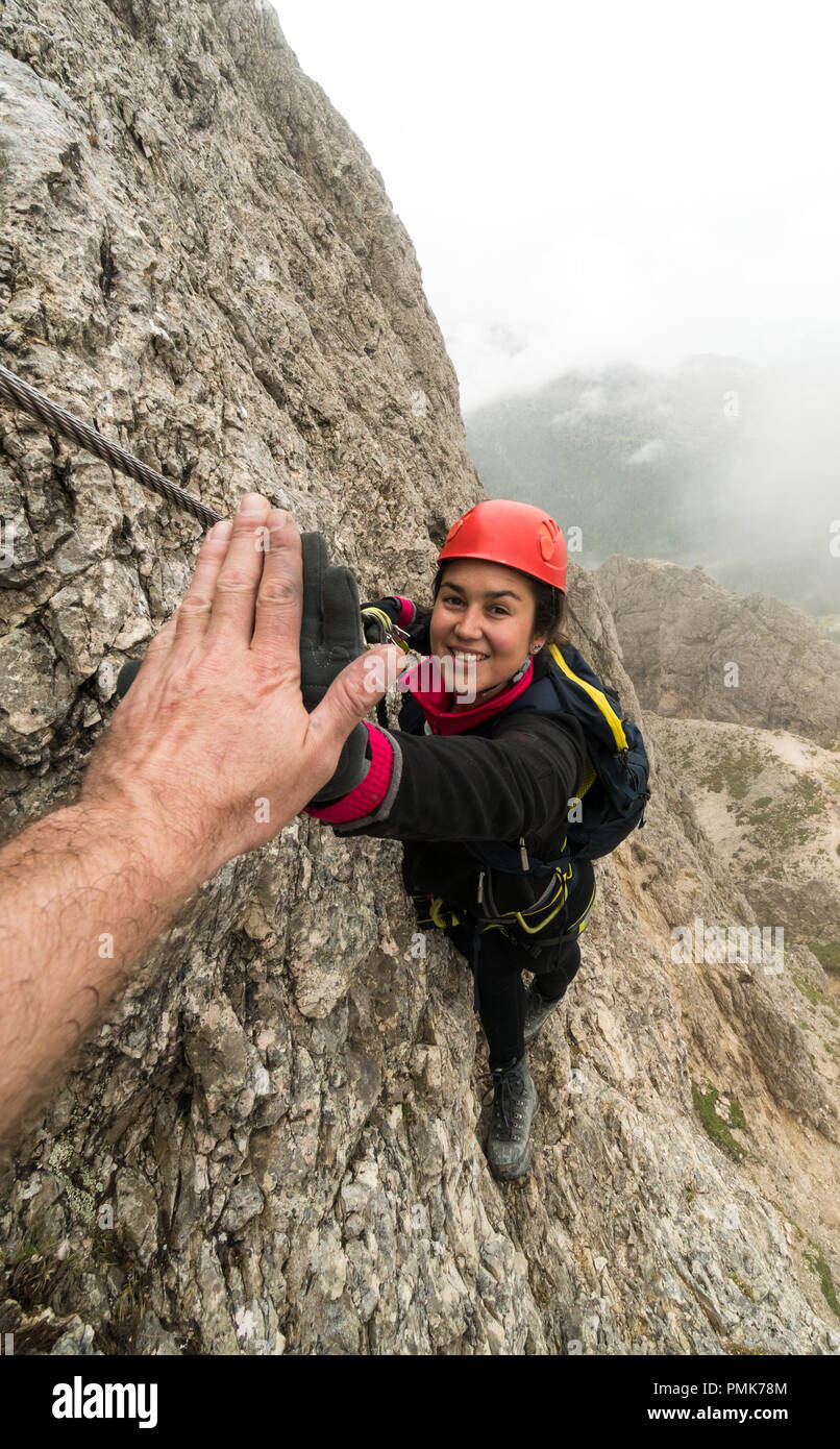 Les jeunes femmes attrayantes d'alpiniste dans les Dolomites de l'Italie lui donnant un guide pour le succès de cinq Banque D'Images