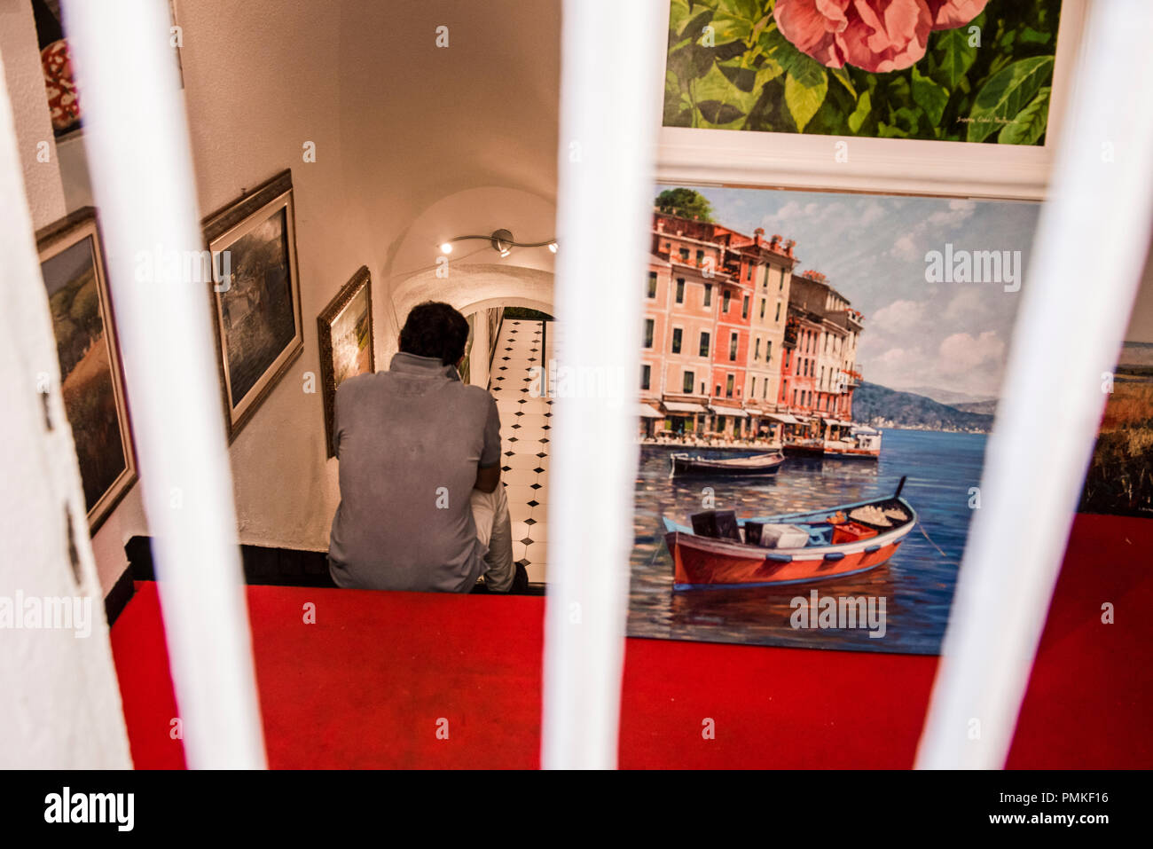 Homme assis sur les marches en arrière, galerie d'art, portrait, Portofino, Gênes, Italie, Europe Banque D'Images