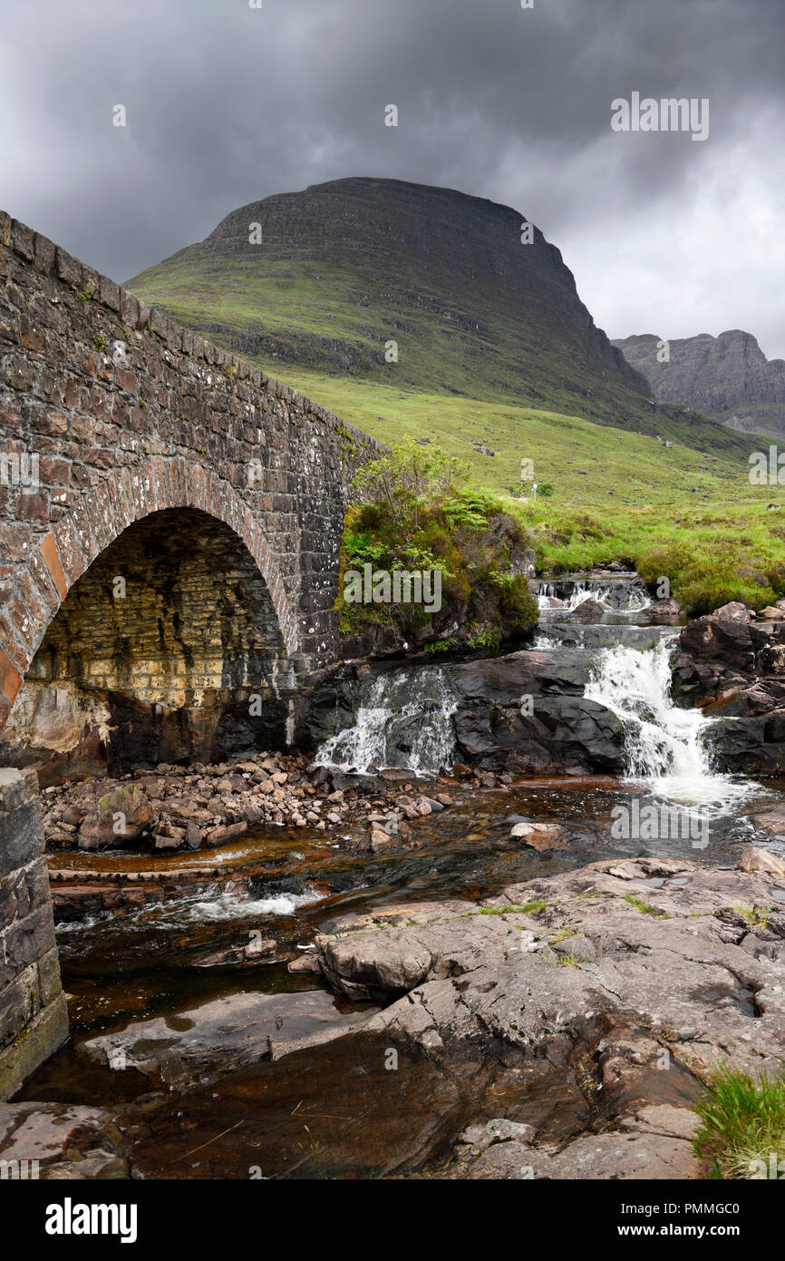 Pont de pierre de Bealach na Ba road mountain passent au-dessus de la rivière et Sgurr Russel brûler une Chaorachain point culminant en Scottish Highlands Scotland UK Banque D'Images