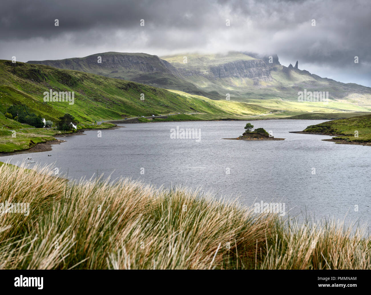 Sur le soleil pommelé Storr pics de montagne avec le vieil homme de Storr dans les nuages et l'île sur le Loch Fada Ile de Skye Highlands écossais Ecosse Banque D'Images