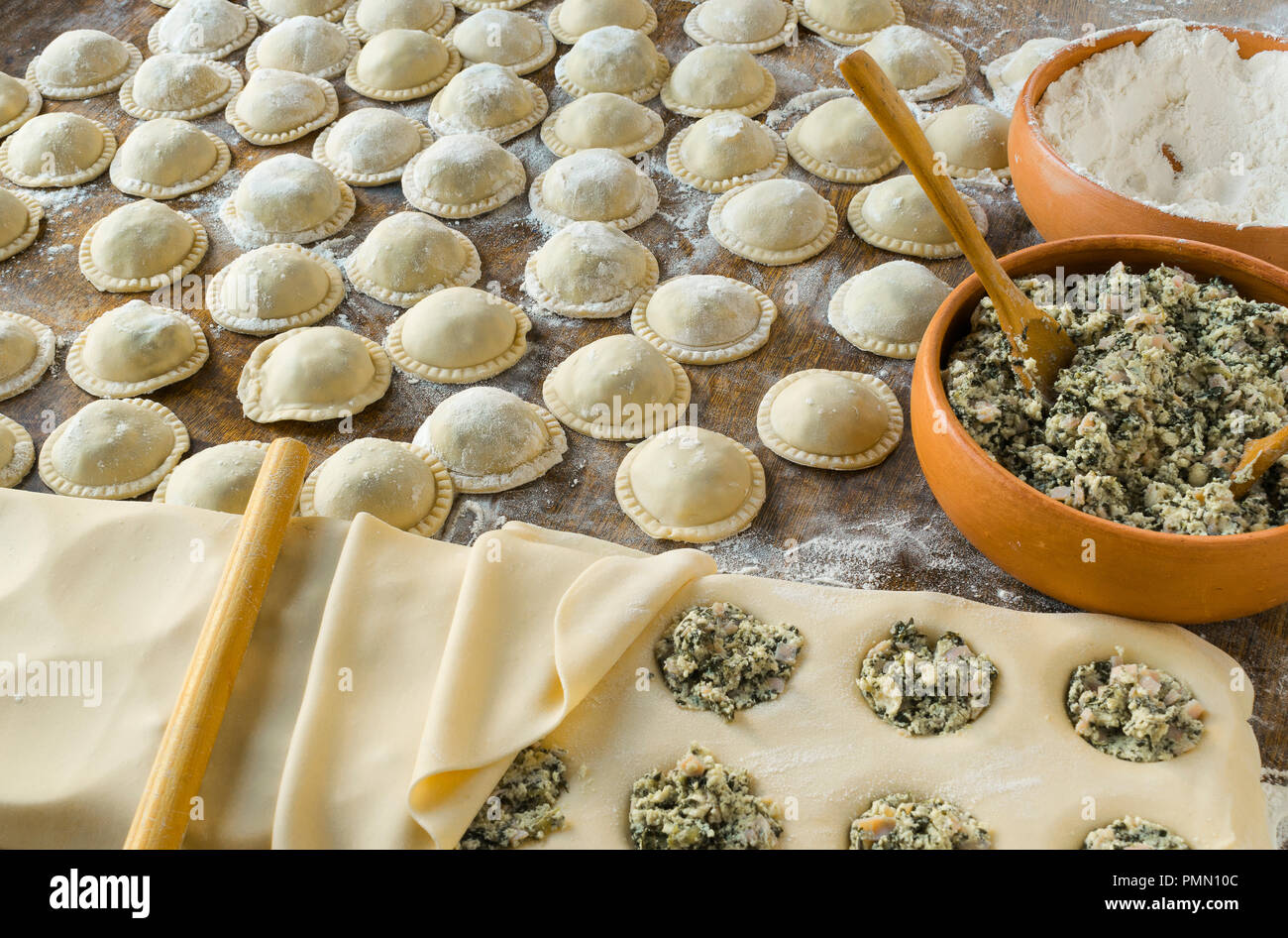 Faire des pâtes : la pâte préparée et pétrie, farcie de fromage, jambon et ricotta, blettes, grand ravioli ronde (Sorrentino) préparé et lu Banque D'Images