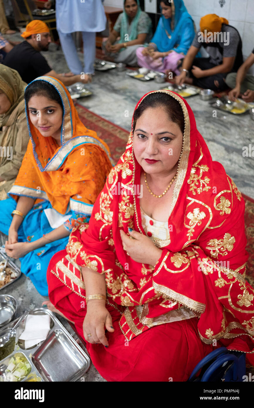 Une femme et sa nièce dans un temple Sikh langar, une pièce où les invités sont servis des plats végétariens. Banque D'Images