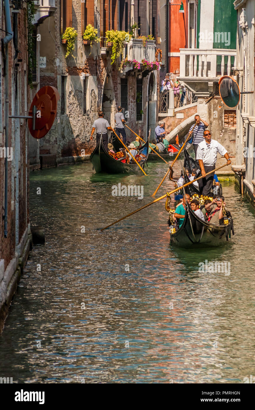 Les touristes transportant les gondoles dans un étroit canal à Venise, Italie. Banque D'Images