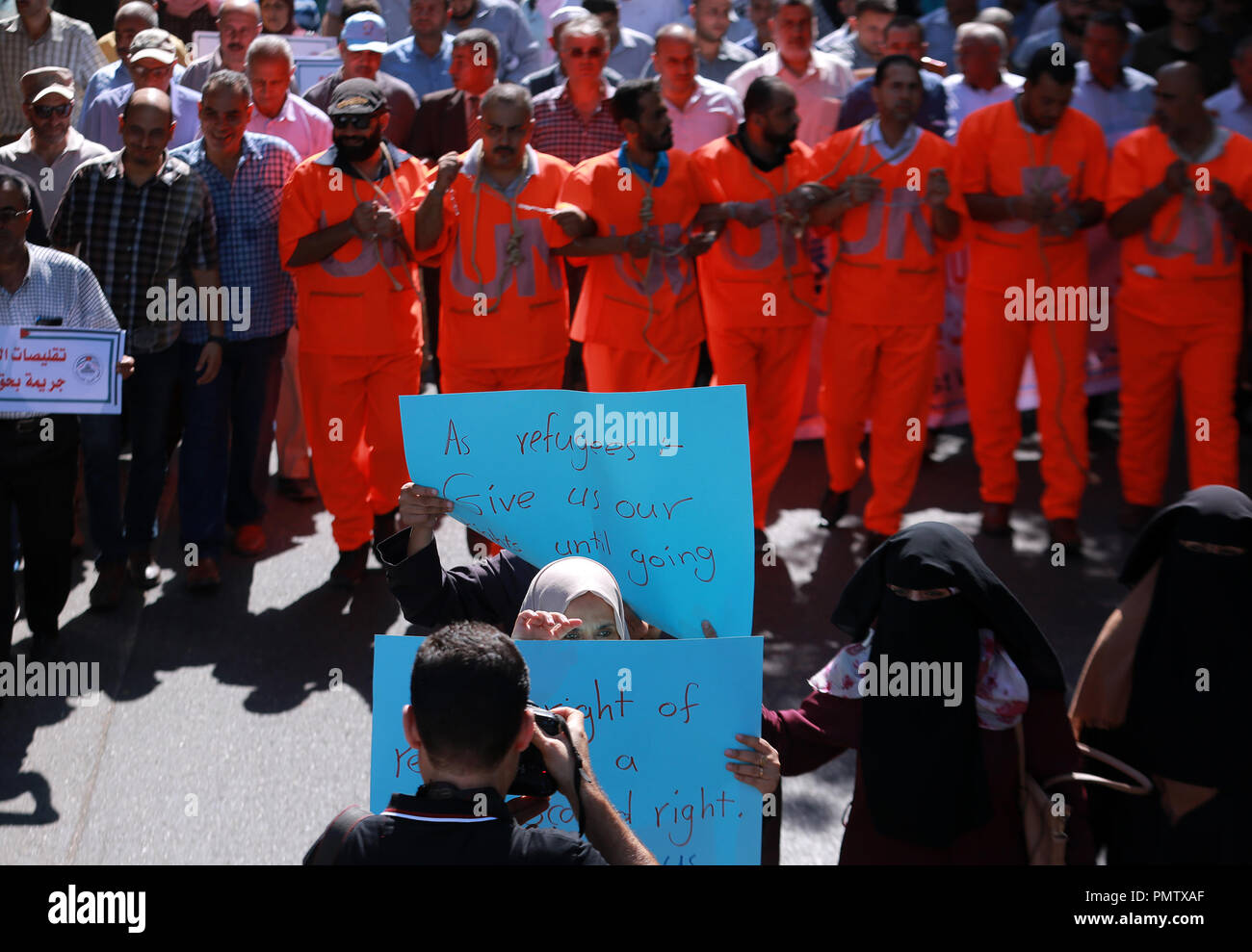 La ville de Gaza, la bande de Gaza, en Palestine. 19 Sep, 2018. Les employés de l'Office palestinien vêtus de combinaisons orange avec les mains enchaînées et la corde autour du cou de protester contre les suppressions d'en face de l'United Nations Relief and Works Agency (UNRWA) siège à la ville de Gaza. Credit : Fadi Thabet/Quds Net News Wire/ZUMA/Alamy Live News Banque D'Images