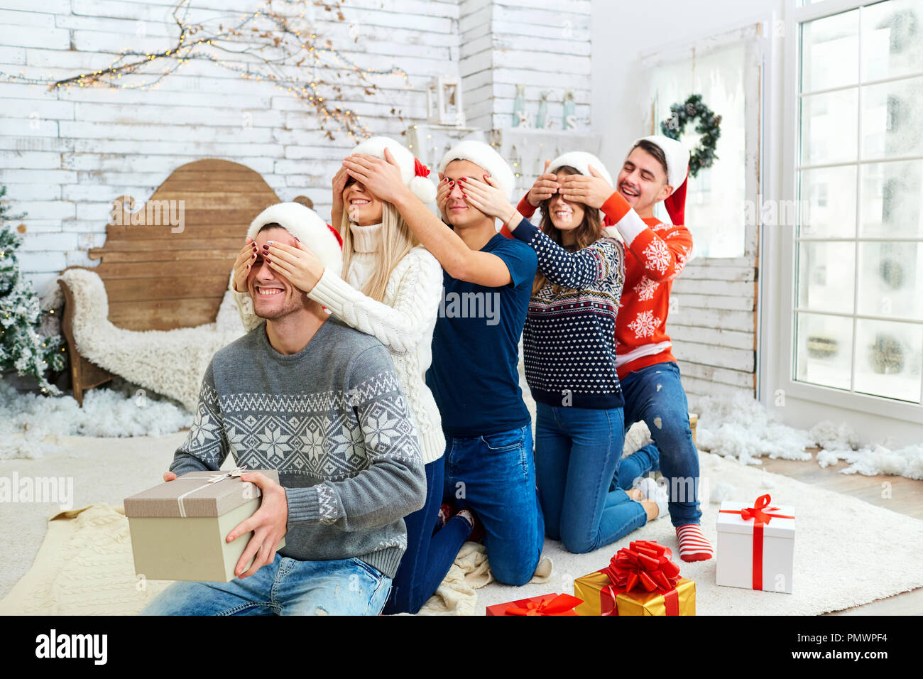 Un groupe d'amis avec des cadeaux à une fête de Noël Banque D'Images