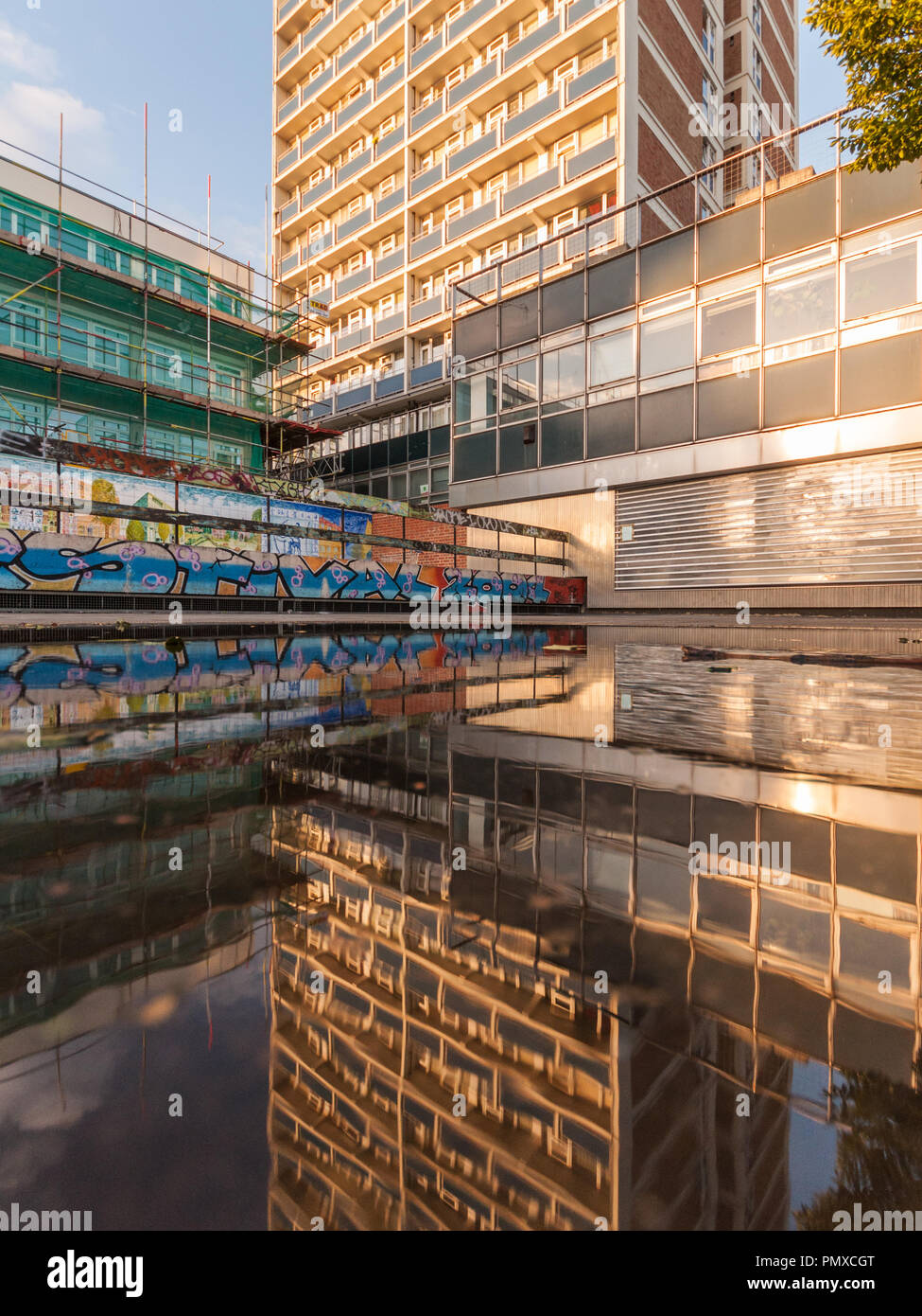 Londres, Angleterre, Royaume-Uni - 24 août 2010 : Immeuble d'habitation reflète dans une flaque sur Old Street à l'Est de Londres. Banque D'Images