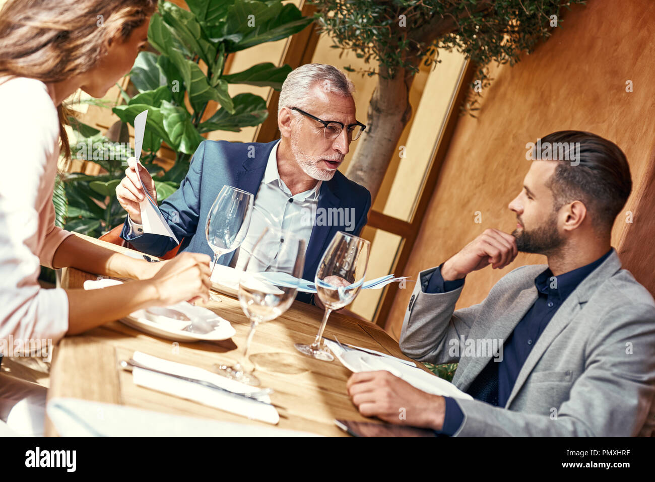 Déjeuner d'affaires. Trois personnes dans le restaurant assis à table à propos de négociation du contrat. Concept de travail d'équipe Banque D'Images