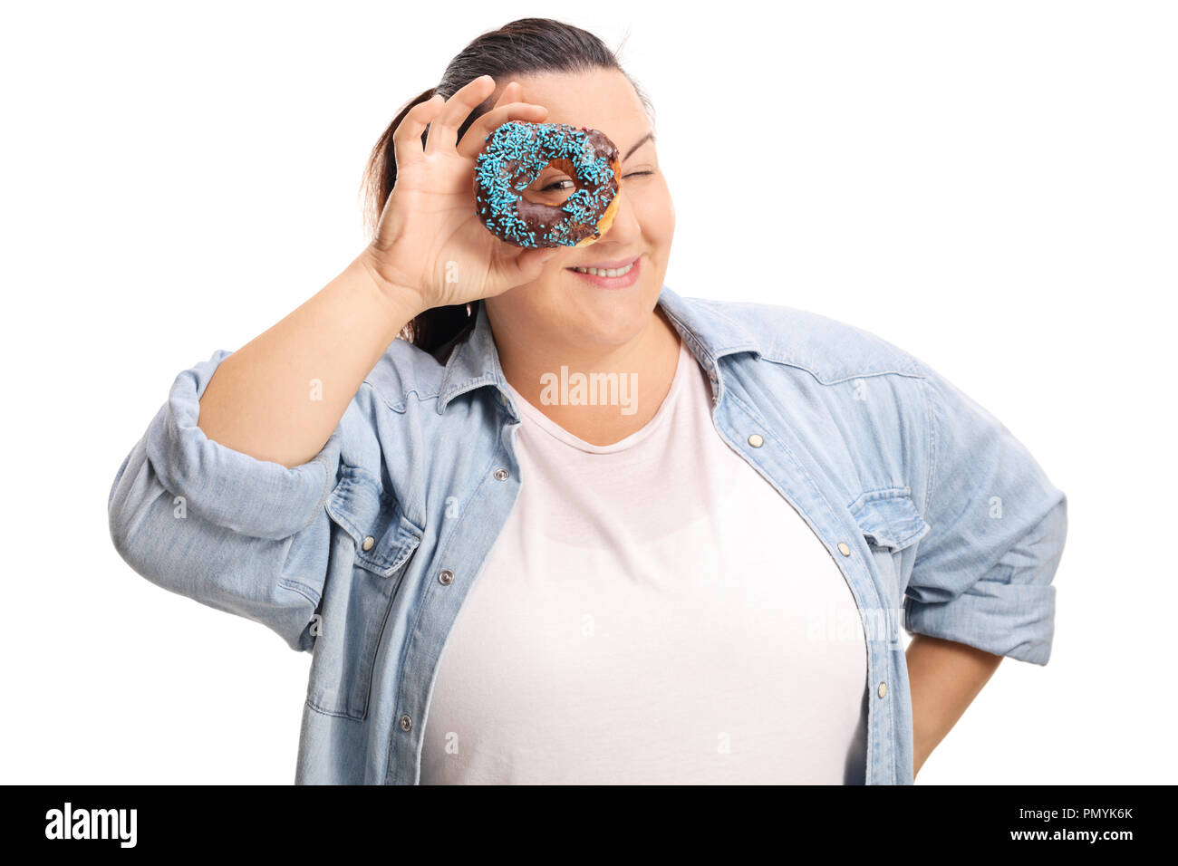 Femme en surpoids peeking through un donut chocolat isolé sur fond blanc Banque D'Images