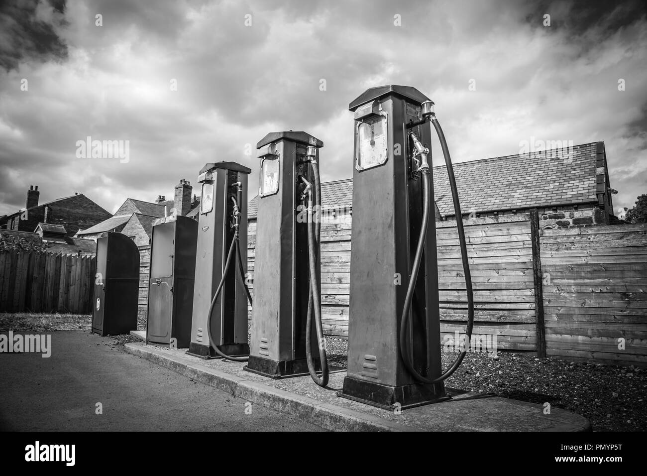 Moody, atmosphère, noir et blanc gros plan de vieilles pompes à essence vintage hors garage vintage, station essence (essence). Des nuages de ciel spectaculaires. Banque D'Images