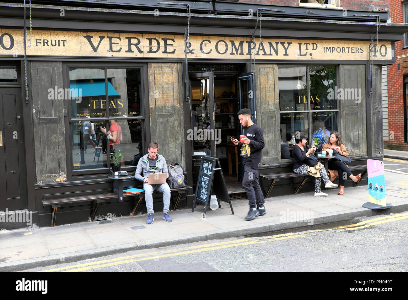 Les gens assis à l'extérieur vert & Company à boire le thé et manger à une table dans l'été à Spitalfields est de Londres Angleterre E1 UK KATHY DEWITT Banque D'Images