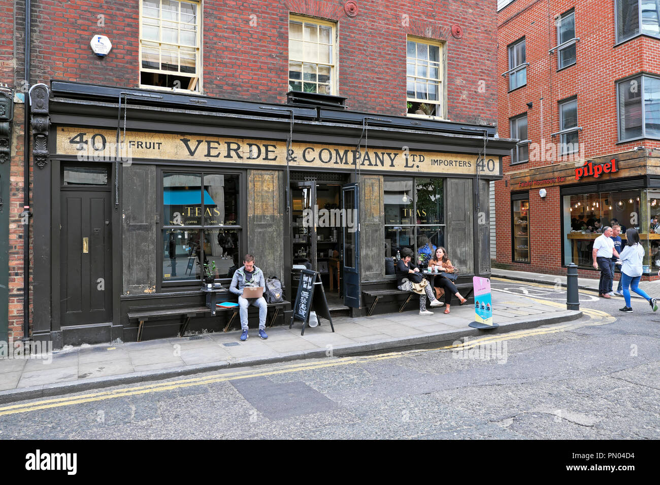 Les gens assis à l'extérieur vert & Company à boire le thé et manger à une table dans l'été à Spitalfields est de Londres Angleterre E1 UK KATHY DEWITT Banque D'Images