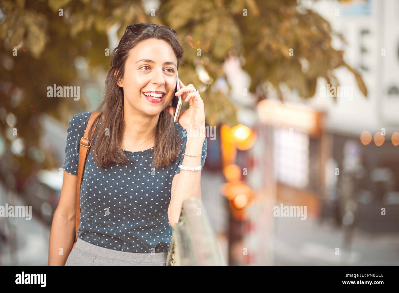Jeune, souriant femme appelant sur un téléphone cellulaire Banque D'Images